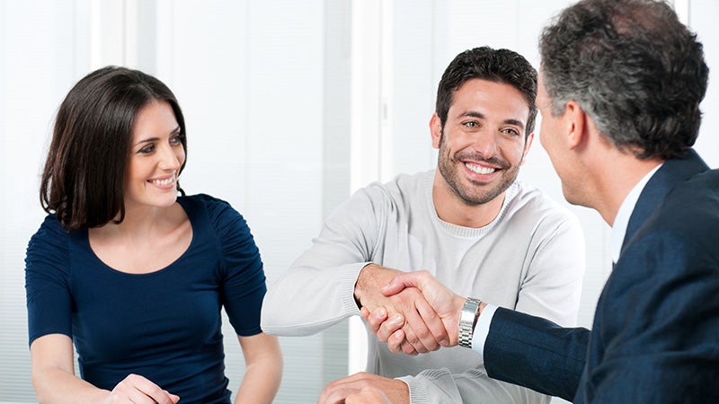 couple shaking hands with salesman Grand Island GMC in GRAND ISLAND NE